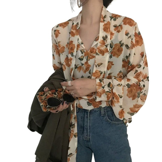 Chemise à fleurs vintage des années 70, motif coloré inspiré des tendances rétro, parfaite pour un look bohème chic.